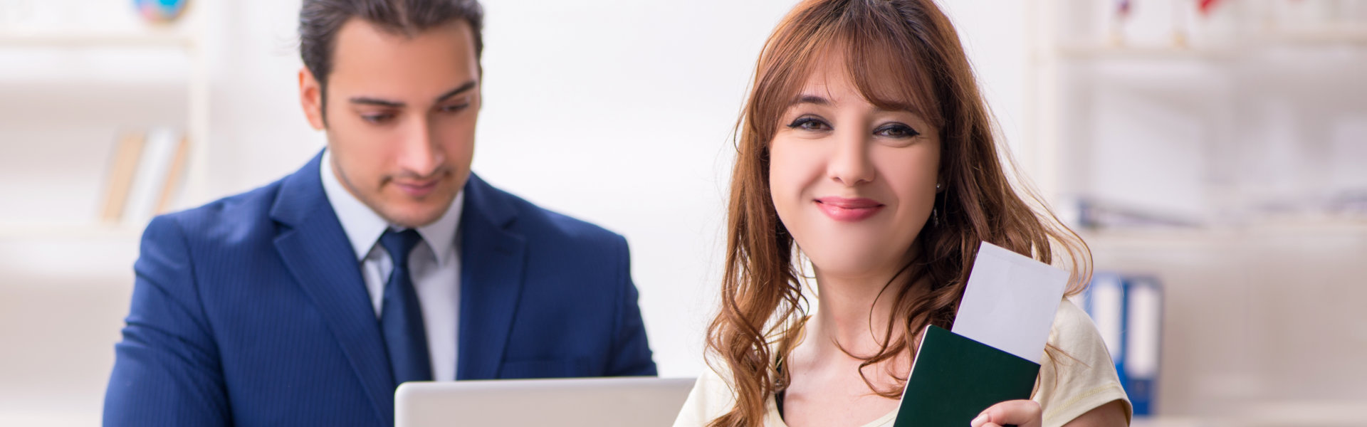 lady holding a card and a man looking at his laptop